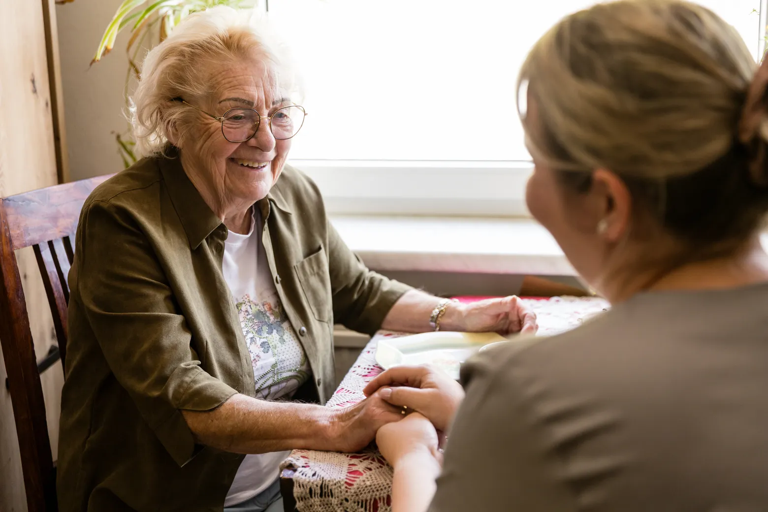 Pflegeberatung nach § 37 Abs. 3: Beratungsgespräch zwischen Pflegefachkraft und Angehörigen im Wohnzimmer